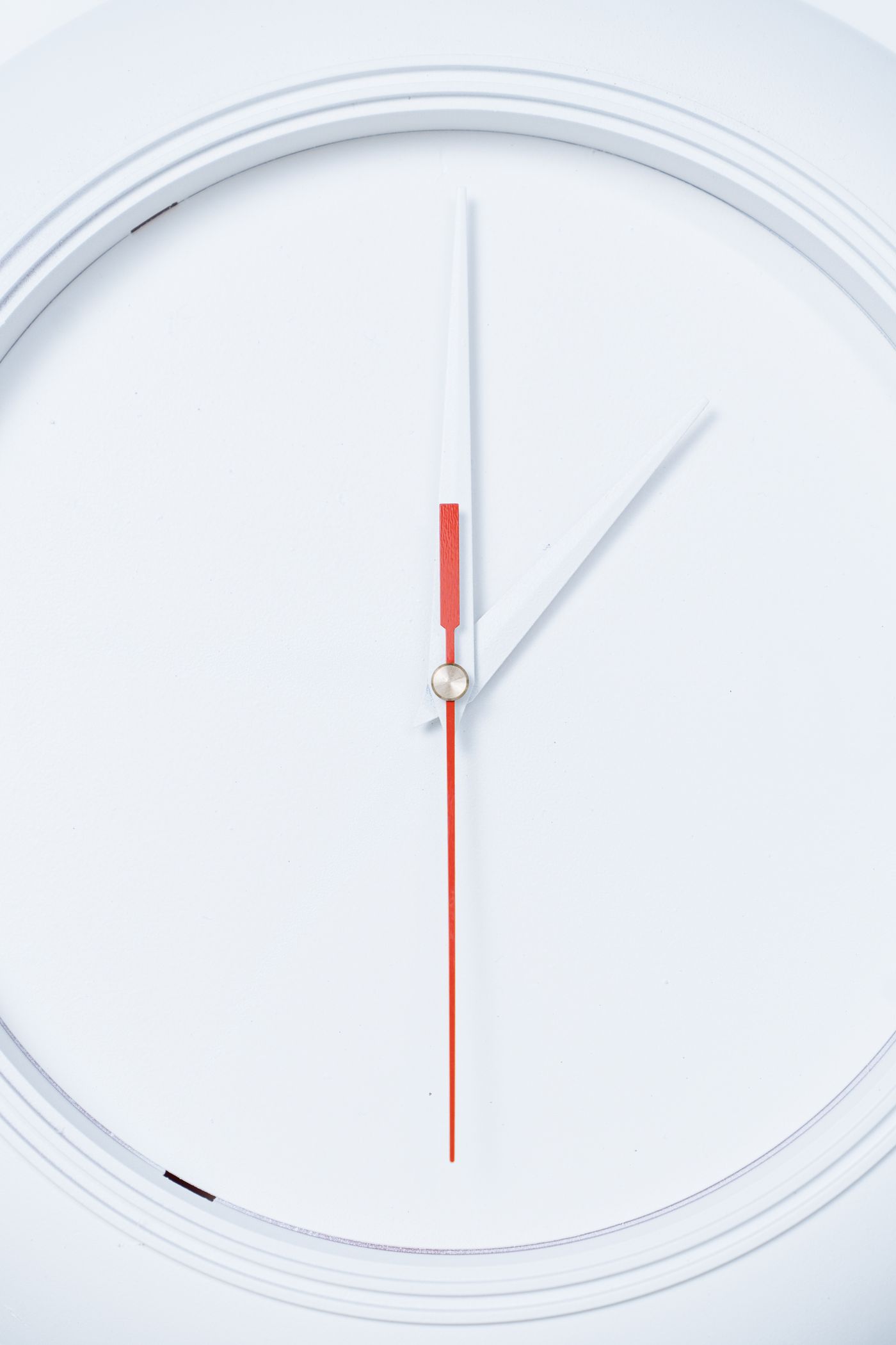 The intact glass cover and rim of a modern white wall clock
